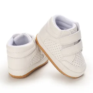 Detail view of stylish white faux leather baby boy walking shoes with velcro straps