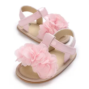 Detalle de sandalias rosas para bebé con flor decorativa de tela y suela blanda flexible