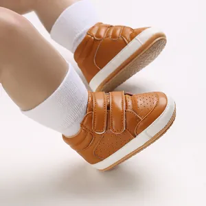 Close-up detail of brown leather baby boys walking shoes with double velcro straps