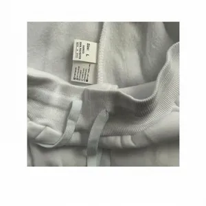 Close-up detail of white garment waistband and care label with washing instructions