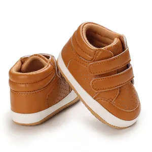 Macro detail of brown faux leather baby walking shoes with double velcro straps