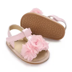 Detalle de sandalias rosa para bebé niña con flores de tela y suelas antideslizantes