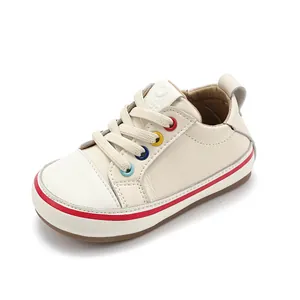 Lässige weiße Lauflernschuhe für Kleinkinder mit bunten Ösen und rotem Sohlenstreifen