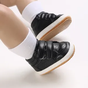 Detailed view of stylish black leather high-top baby walking shoes with velcro straps