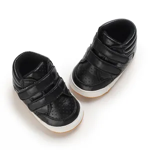 Detailed top view of fashionable black leather baby walking shoes with Velcro straps.