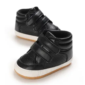 Detail view of black faux leather baby boy walking shoes with dual velcro strap closures
