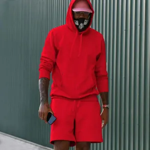 Modelo profesional con conjunto de sudadera con capucha y pantalones cortos de felpa roja hombre