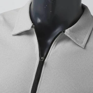 Close-up view of the gray waffle knit texture and zipper on this men's polo jacket