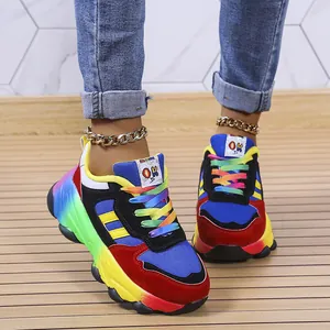 Vista dettagliata di vivaci sneakers con zeppa arcobaleno con lacci colorati e tomaia