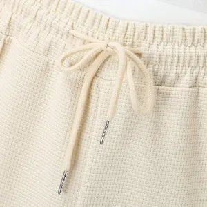 Primer plano de la textura de punto de gofre y la cintura con cordón del pantalón