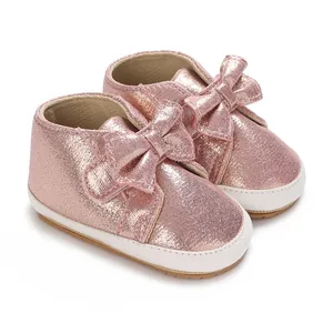 Vue détaillée de jolies chaussures de marche rose pailleté pour bébé fille avec un grand nœud