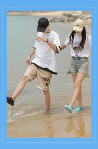 Pareja con zapatos de agua de secado rápido caminando por la orilla de la playa.
