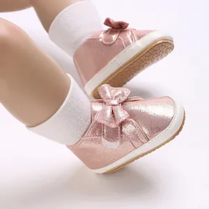Vue détaillée des chaussures pour bébés rose pailleté avec semelles souples et nœuds mignons