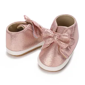 Chaussures de marche roses scintillantes pour bébé fille avec nœud et semelle souple.