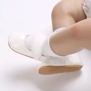Dettaglio scarpe da neonato in pelle verniciata bianca con morbida ecopelliccia e suola flessibile