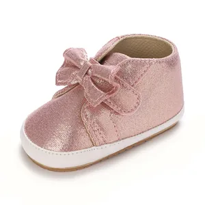 Vue détaillée d'une chaussure bébé pailletée rose avec un nœud décoratif mignon