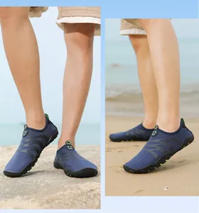 Detalle de zapatos de agua descalzos azul marino transpirables usados en una playa de arena