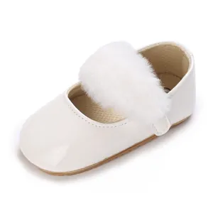 Primo piano di scarpe bianche primi passi per neonati con morbido pompon bianco soffice.