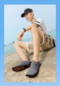Zapatos de agua grises y transpirables para hombre sentados en rocas junto al mar
