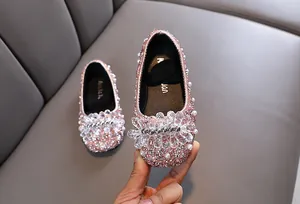 Dettaglio scarpe da principessa rosa glitterate per bambine con perle e fiori