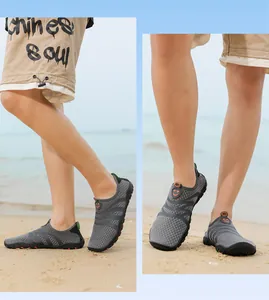 Vista de detalle de zapatos de agua grises transpirables usados por un modelo en la playa