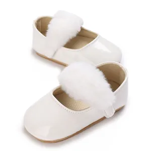 Vista dettagliata di scarpe da neonato in vernice bianca con cinturini in ecopelliccia