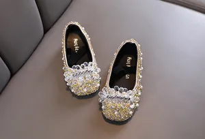 Dettaglio ravvicinato di scarpe da principessa scintillanti per bambine con perle e strass