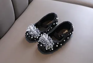 Dettaglio di scarpe da principessa nere per bambina con cristalli e perle