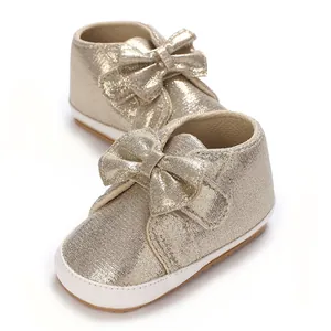 Gros plan de chaussures dorées métallisées pour bébé avec un élégant nœud décoratif chic