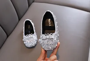 Primo piano di scarpe da principessa per bambina con strass e perle brillanti