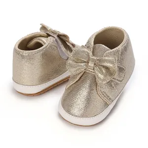Vue détaillée de chaussures dorées pour bébé fille avec semelle souple et nœud élégant