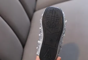 Dettaglio ravvicinato della suola antiscivolo di scarpe da principessa argento lucido