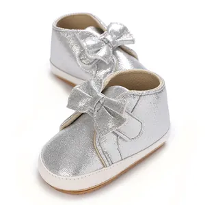 Vue détaillée de chaussures de marche argentées pour bébé fille avec un grand nœud et semelle souple