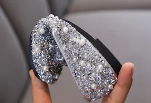 Dettaglio ravvicinato di scarpe da principessa per bambina con strass e perle.