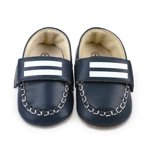 Makro-Detailansicht von dunkelblauen Kunstleder-Babyschuhen mit weißen Streifen.