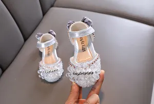 Nahaufnahme von funkelnden silbernen Prinzessinnenschuhen mit Kristallperlen für Mädchen