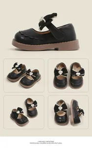 Vistas detalladas de zapatos Mary Jane negros para niña con lazos y corazones decorativos