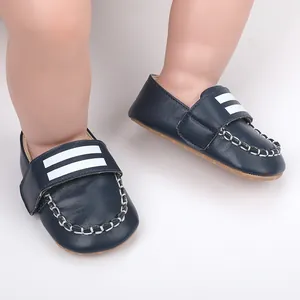 Nahaufnahme von dunkelblauen Baby-Lauflernschuhen mit weißem Streifen und Kontrastnähten