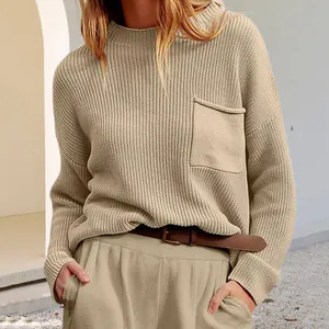 Gros plan détaillé d'un pull en maille beige à col rond avec une poche de poitrine pratique.