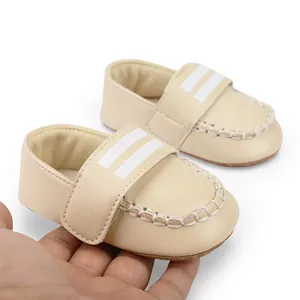 Detail von weichen beigen Baby-Lauflernschuhen mit weißen Streifen für 0-1-Jährige