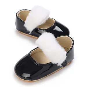 Dettaglio scarpe neonata in vernice nera lucida con cinturino in ecopelliccia
