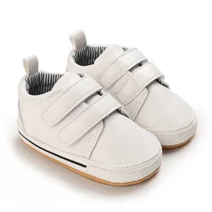 Detail view of white baby walking shoes with double Velcro straps and anti-slip sole