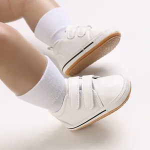 Macro view of white baby walking shoes with dual velcro straps and anti-slip rubber soles
