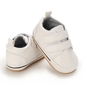 Close-up view of white infant baby boy pre-walker shoes with double velcro straps