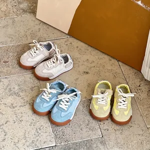Drei Paar farbenfrohe Lauflernschuhe für Kleinkinder auf einem stilvollen Steinfußboden