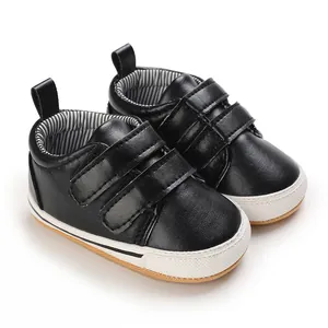 Close-up detail of black baby walking shoes with dual velcro straps and anti-slip sole