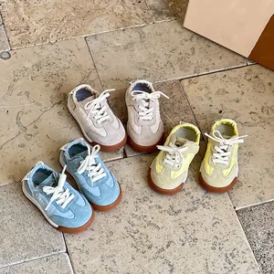 Detailansicht von drei bunten Lauflernschuhen für Babys auf Steinboden