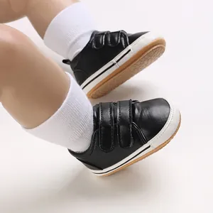 Close-up of black baby walker shoes with double magic sticker straps on mannequin feet.