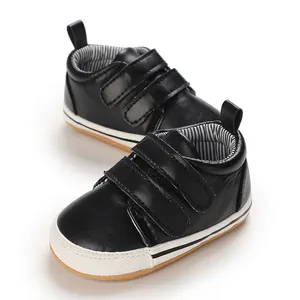 Detailed view of black infant walking shoes with double velcro straps and non-slip rubber soles