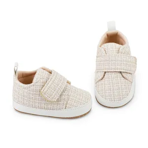 Detaillierte Nahaufnahme von weichen Baby-Lernlaufschuhen aus beigem Tweed-Gewebe